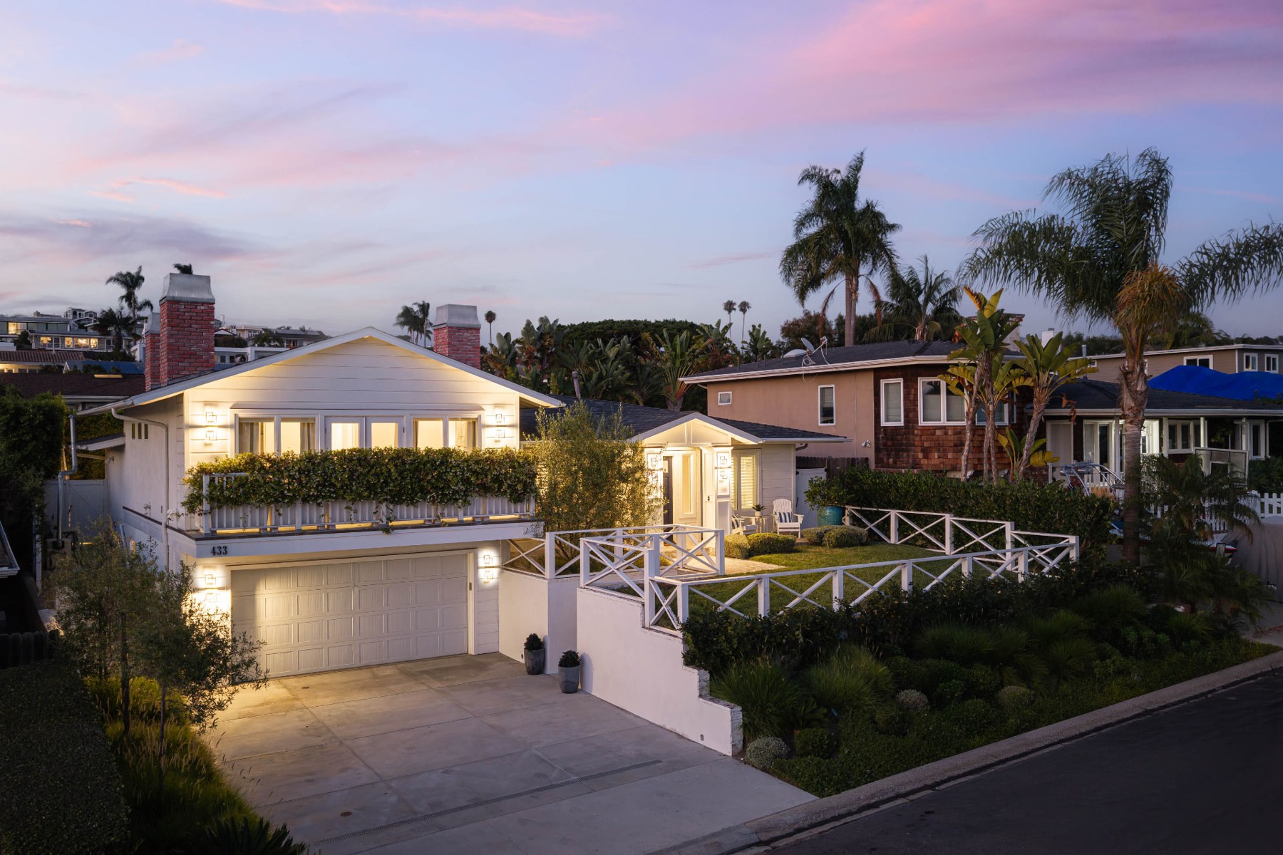 433 Seaward Road viewed from the street at dusk, with palm trees and the front garden