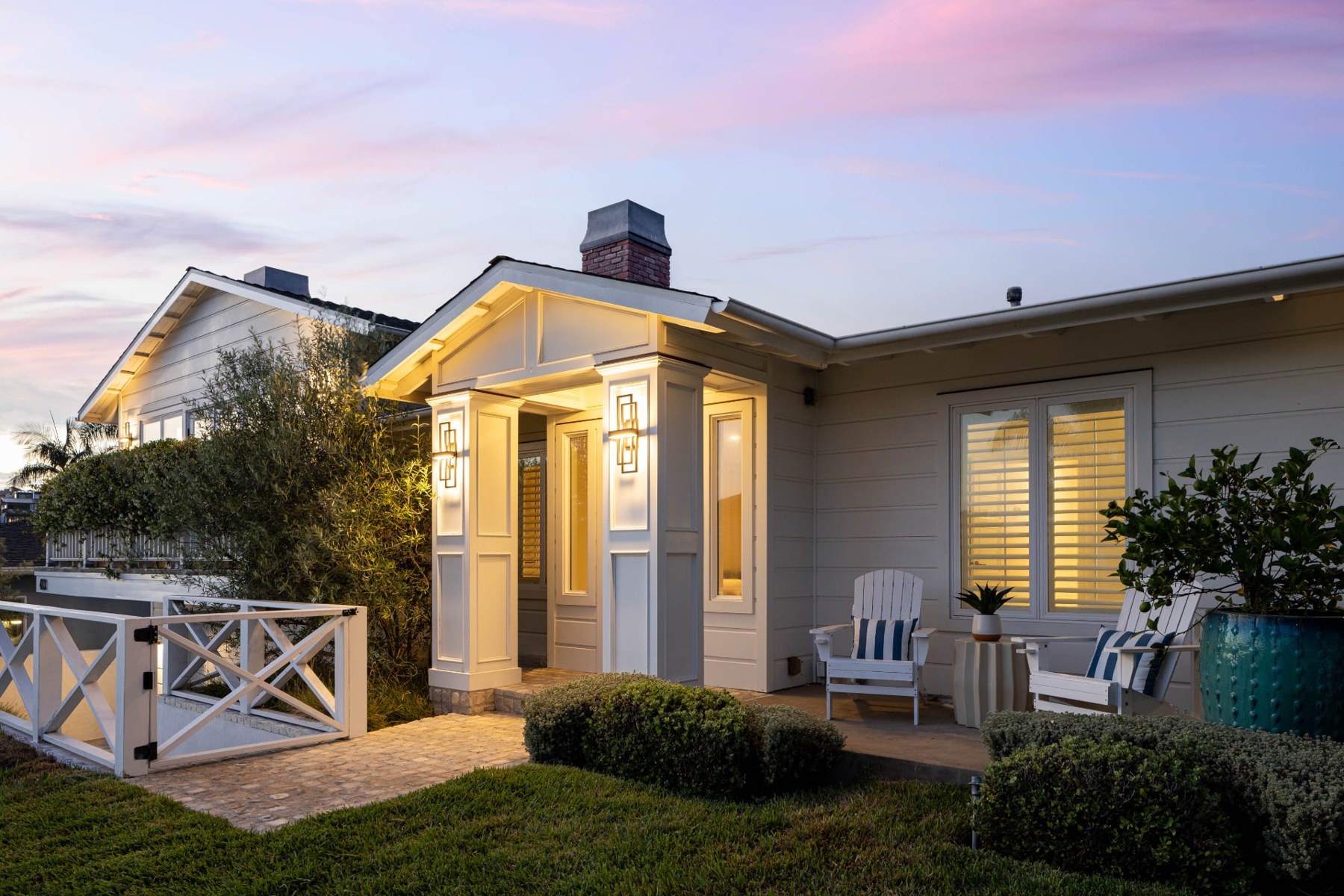 Front garden and illuminated entry at 433 Seaward Road under a pink twilight sky