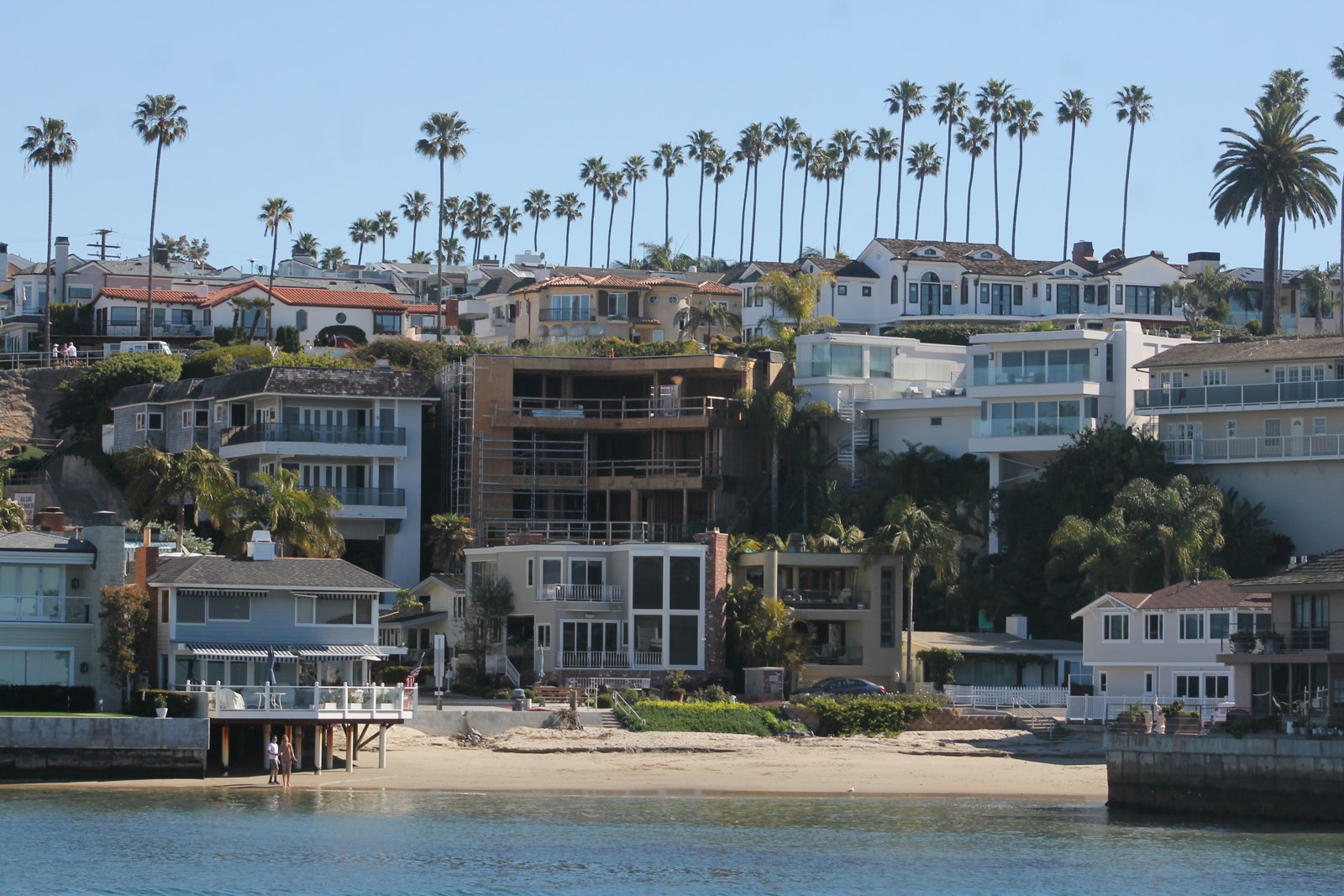 Real Newport Beach coastal homes and palms above the water
